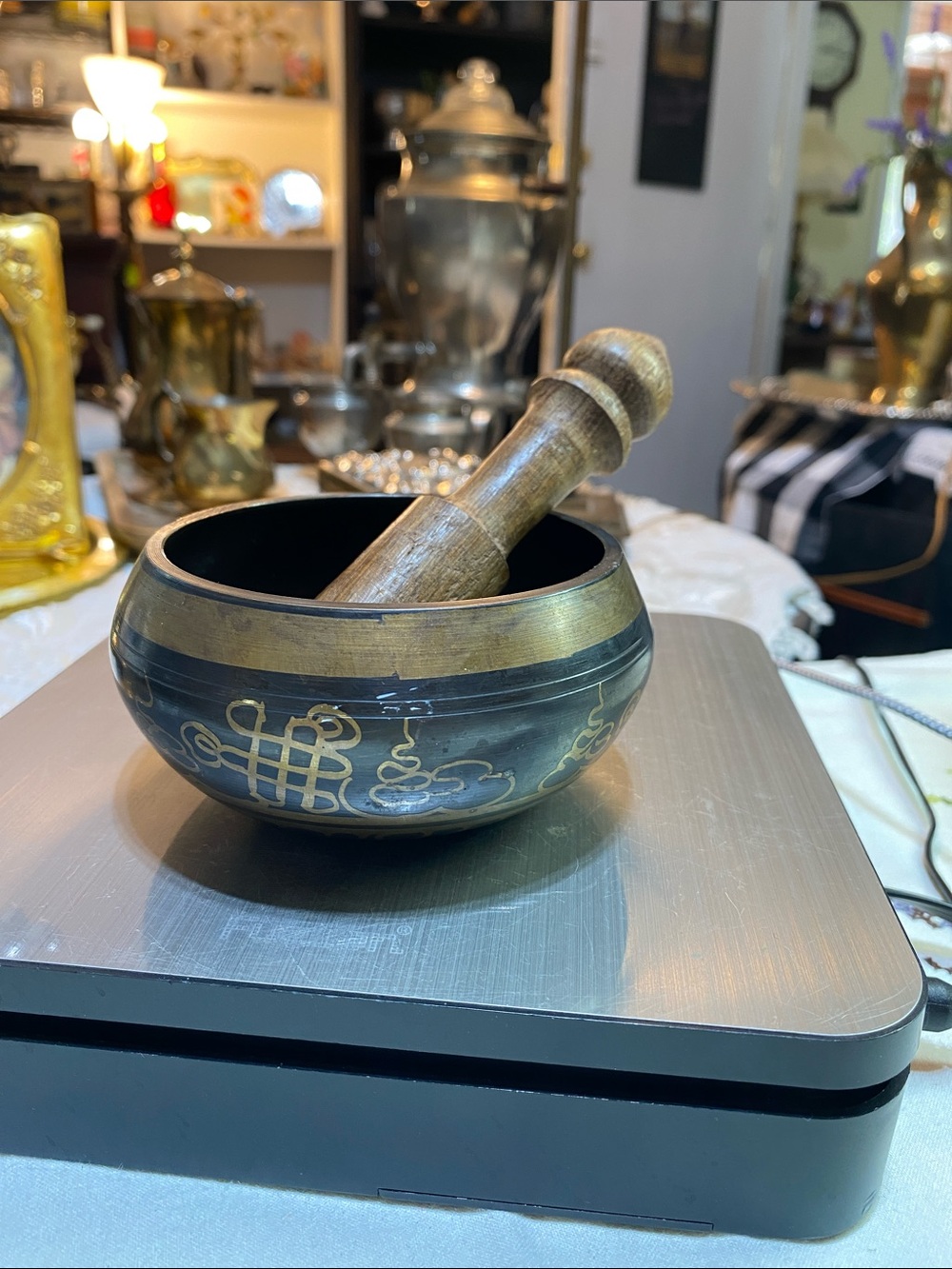 Tibetan singing bowl with an etched "endless knot" symbol and a wood mallet